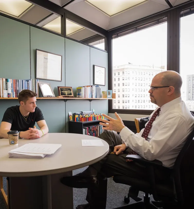 two people sitting at a table and talking